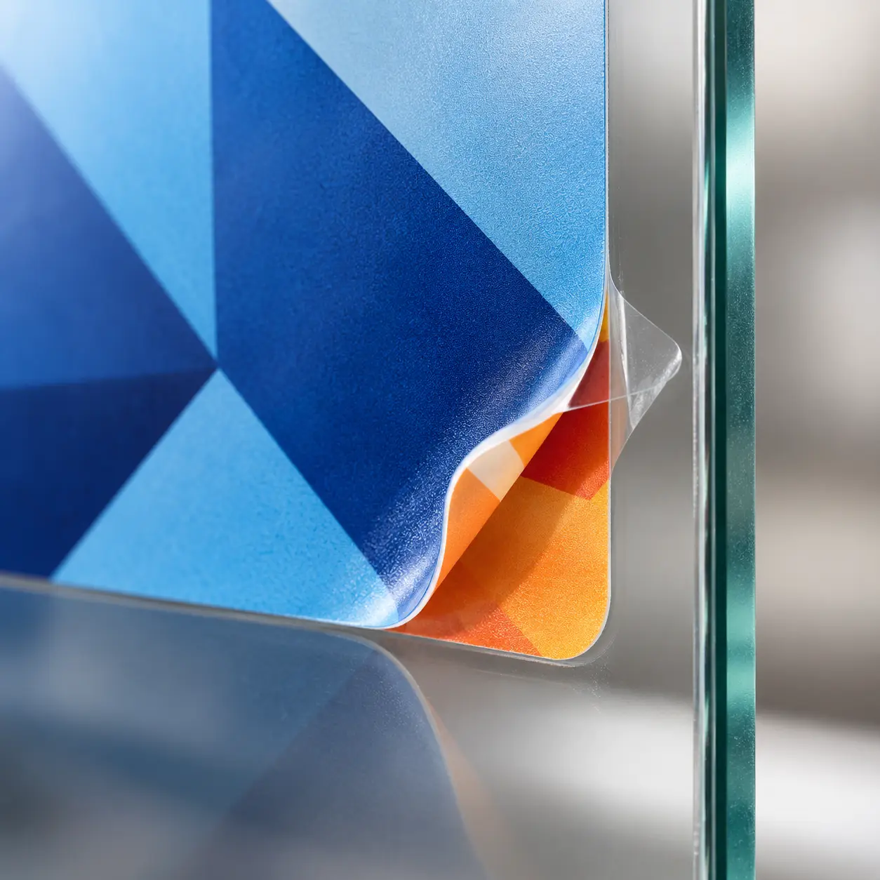 Close-up of layered double-sided clear vinyl sticker on glass